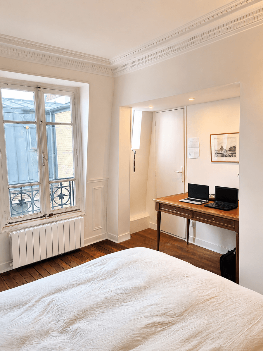 Chambre aux murs et moulures repeints en blanc, parquet ancien conservé
