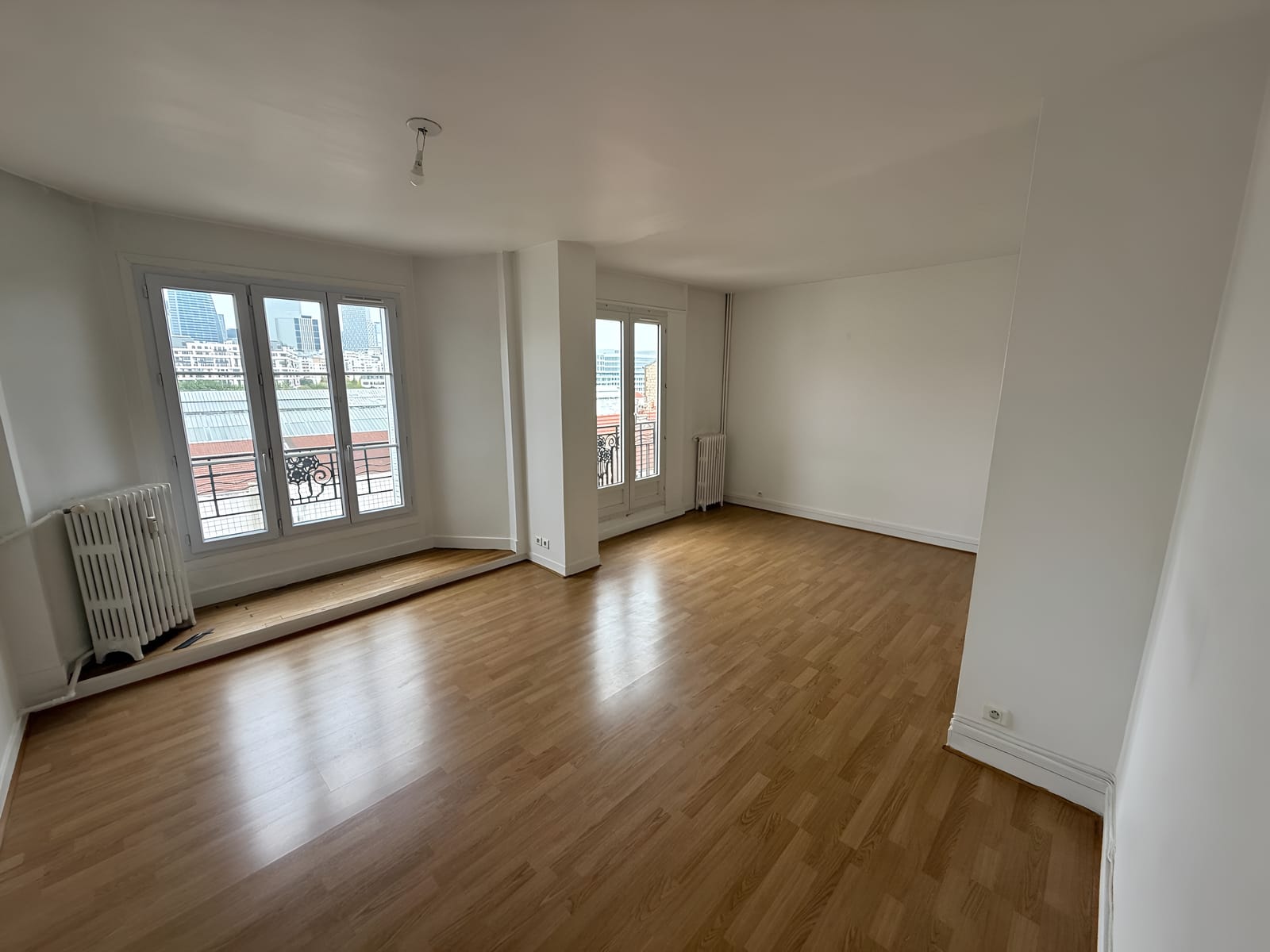 Séjour d'un appartement remis en peinture avant relocation, vue sur La Défense
