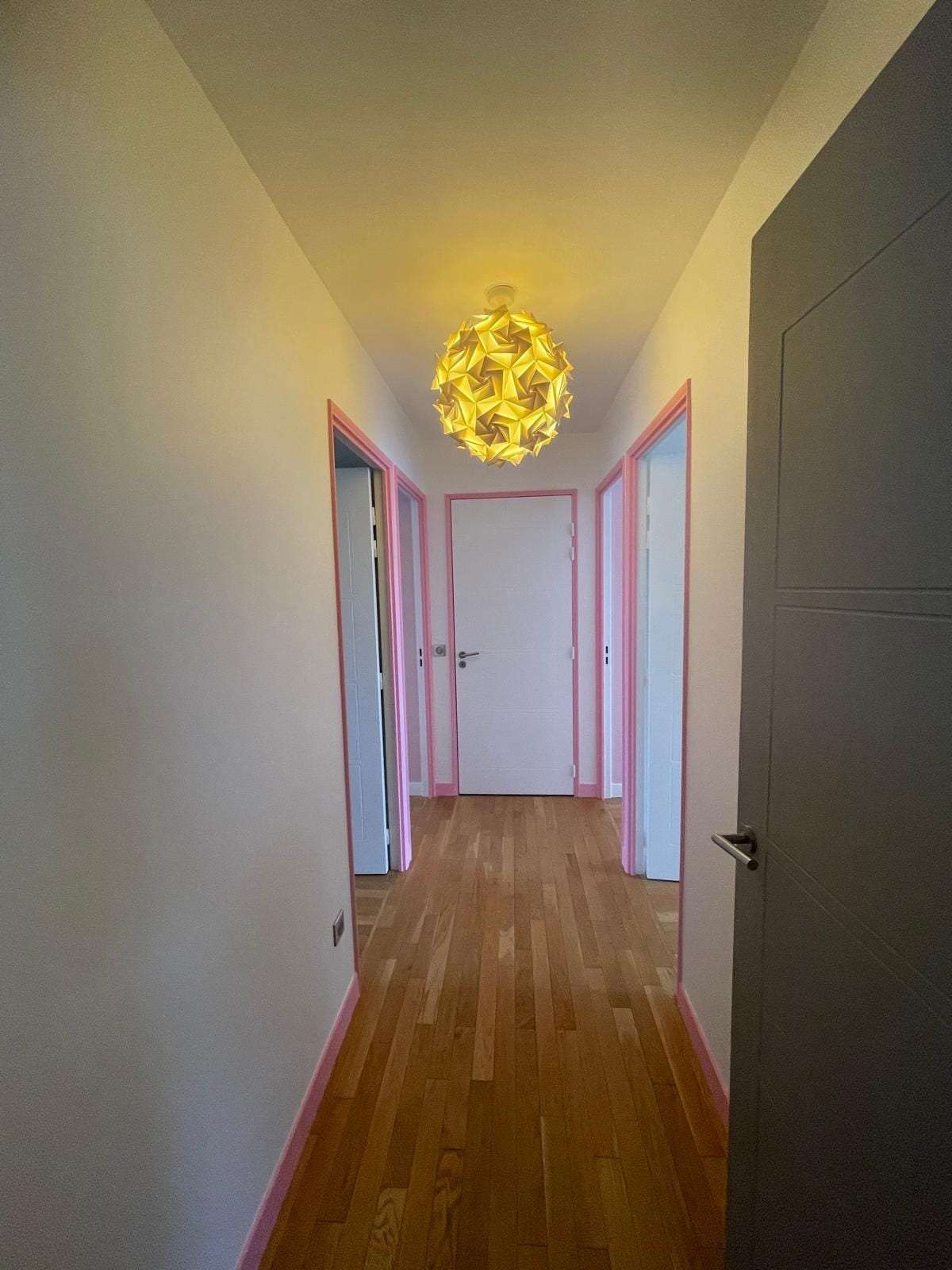 Couloir repeint à Boulogne-Billancourt, plinthes et encadrements Rose de porcelaine, portes blanches