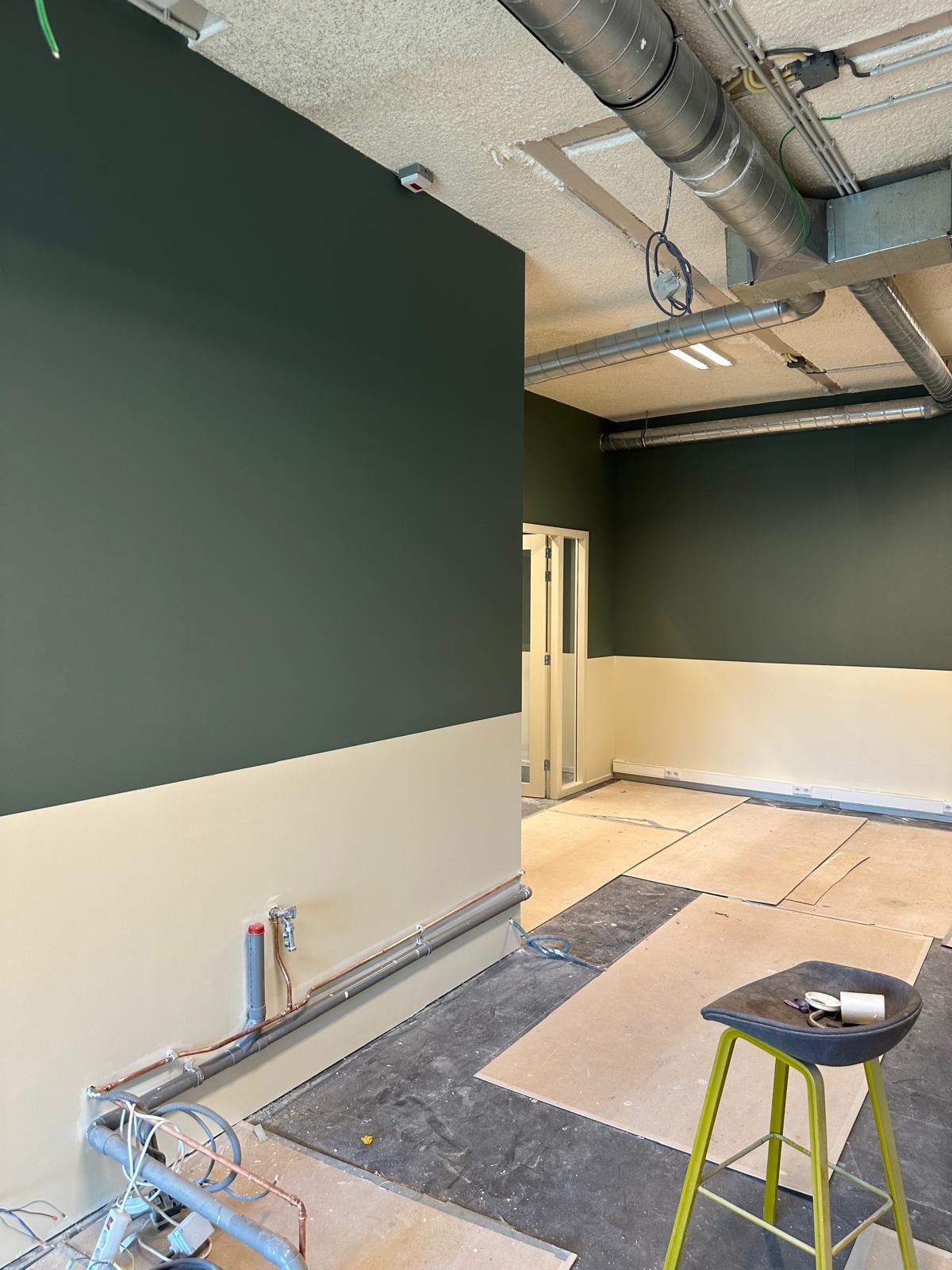 Bureau partagé aux murs vert profond et soubassement clair à Bois-Colombes