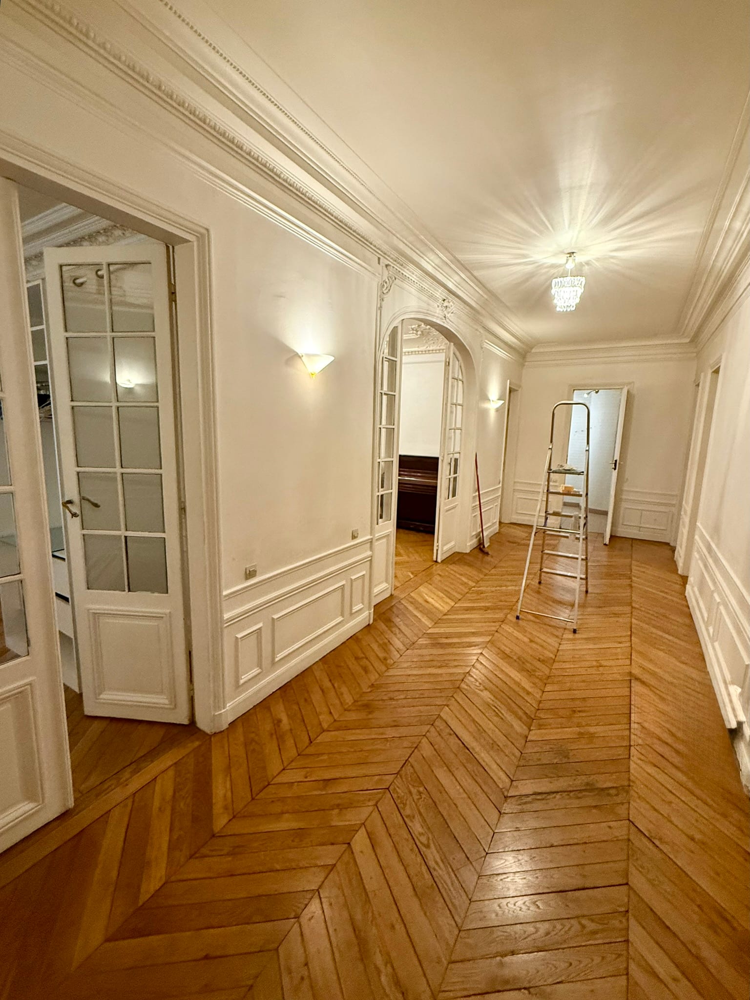 Couloir d'appartement fraîchement repeint à Bois-Colombes, moulures et parquet préservés