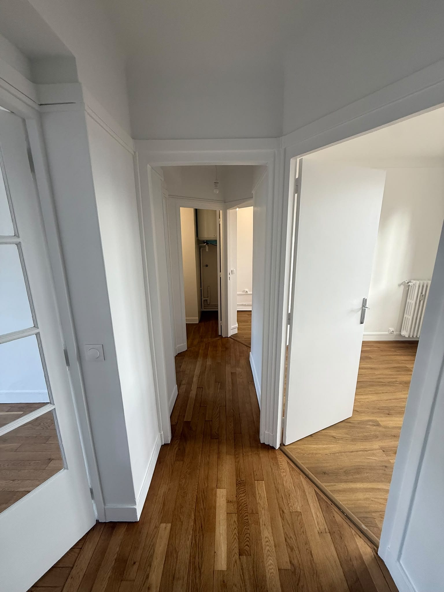 Entrée en enfilade, portes, encadrements et plinthes repeints en blanc