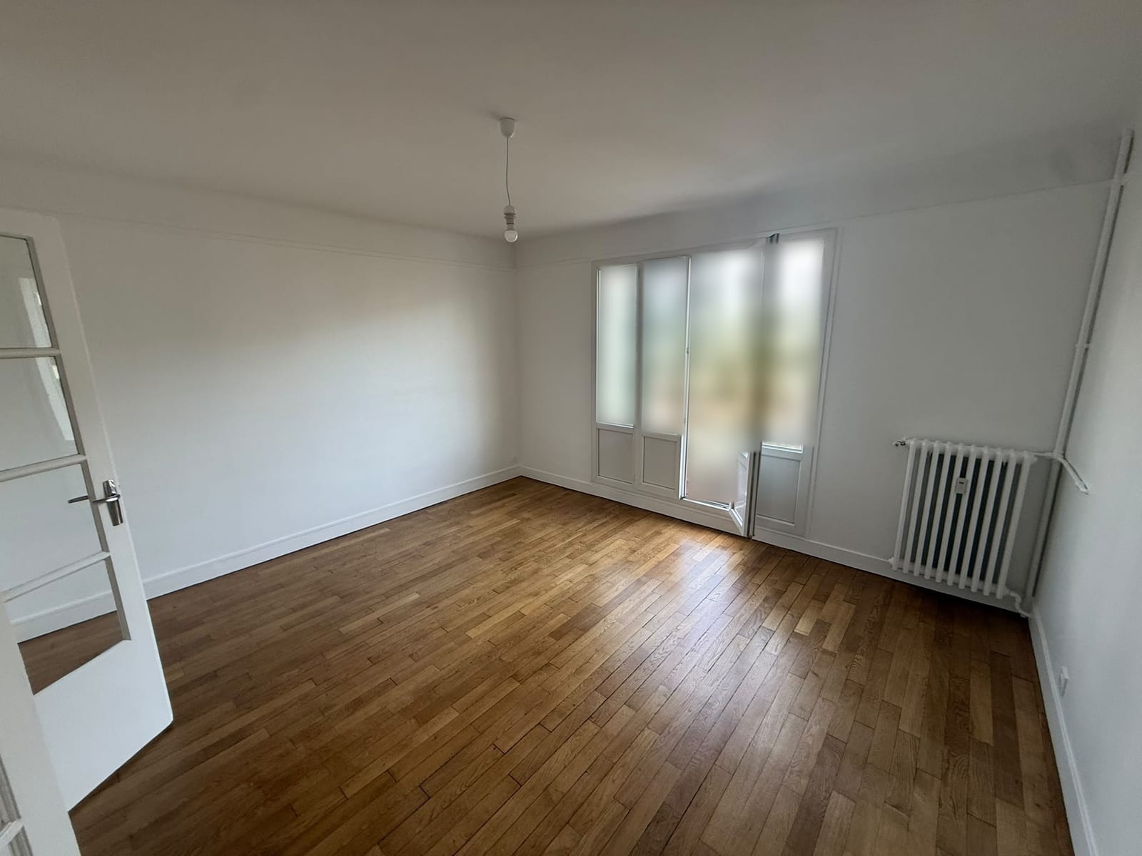 Séjour repeint en blanc à La Garenne-Colombes, plafond, murs et porte-fenêtre ouverte sur le balcon