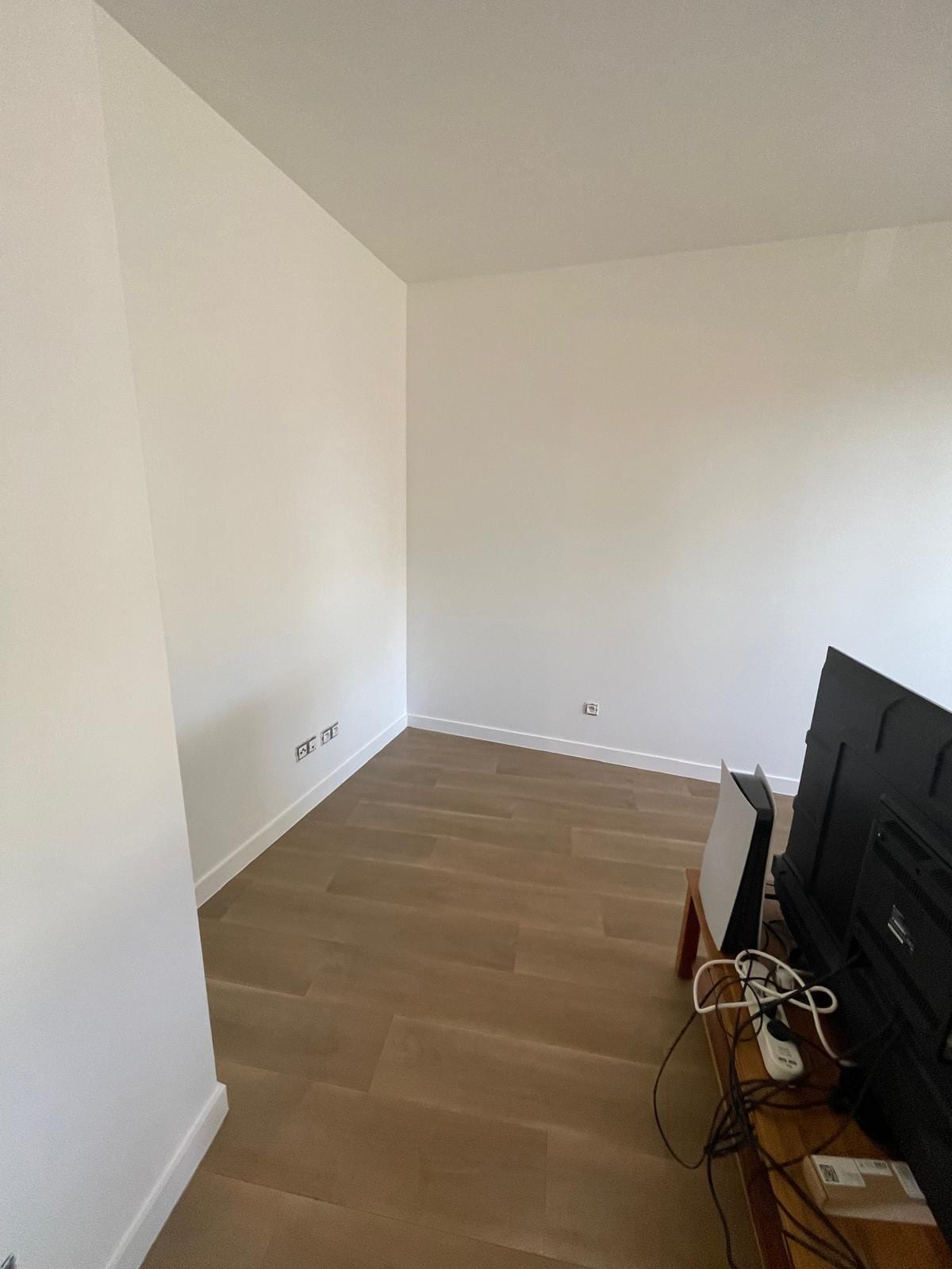 Pièce repeinte en blanc, sol stratifié, logement vide