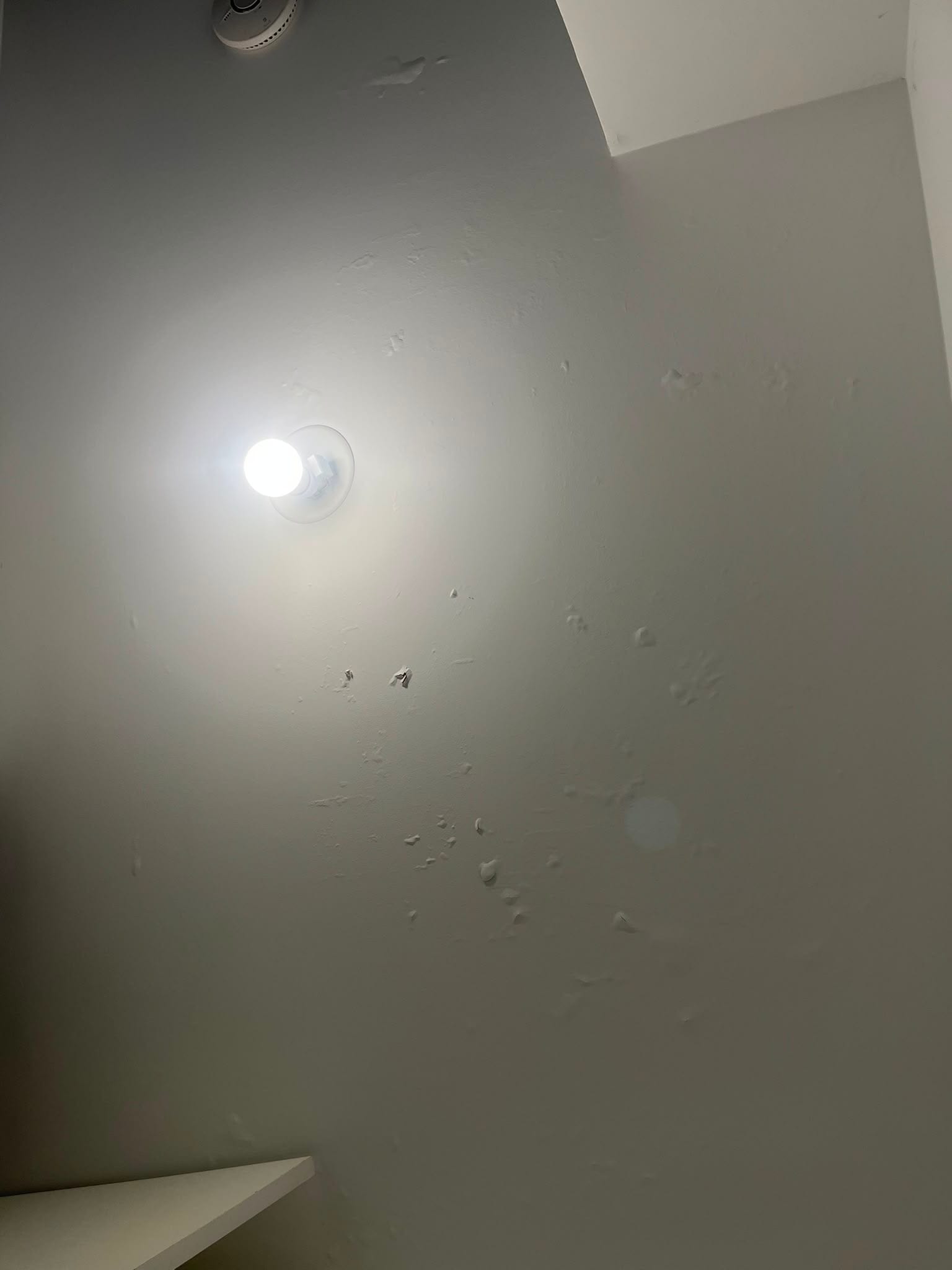 Plafond de couloir cloqué près du luminaire avant travaux